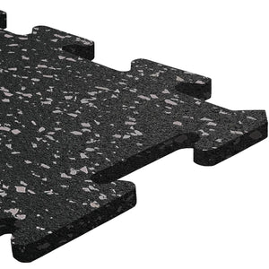 A close-up of an ECORE Athletic ECORE Rubber Floor Tiles - 8mm Interlocking tile, featuring a black surface with gray speckles, textured finish, and puzzle-like connecting edges.