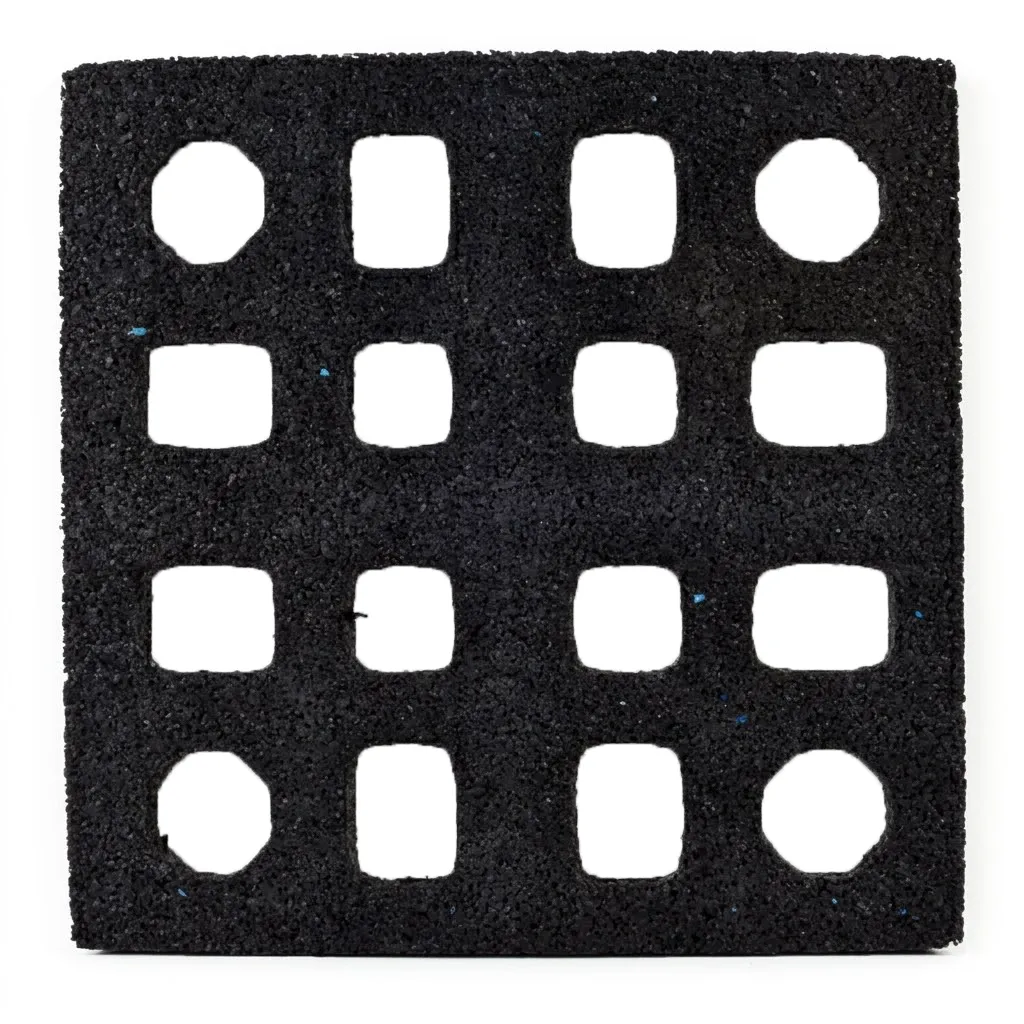 The ECORE Quad Blok Connector for 2.5" Tiles by ECORE Athletic is a black square mat featuring a 4x4 grid of evenly spaced, square cutouts with slightly rounded corners and a rough, textured surface.