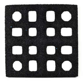 The ECORE Quad Blok Connector for 2.5" Tiles by ECORE Athletic is a black square mat featuring a 4x4 grid of evenly spaced, square cutouts with slightly rounded corners and a rough, textured surface.