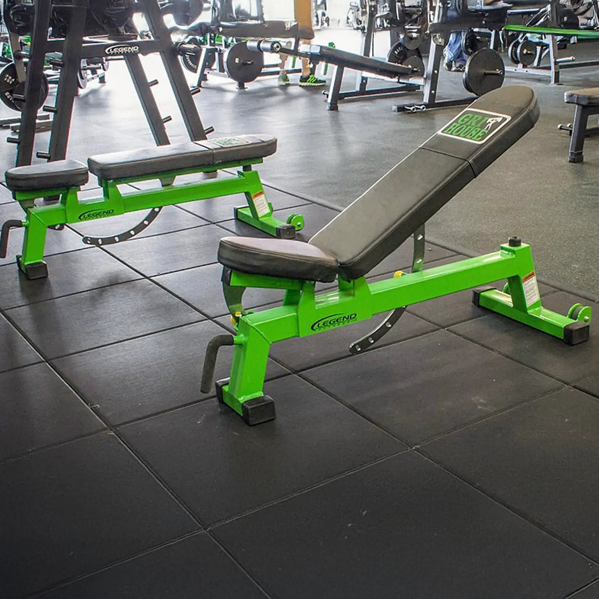 Green and black weight bench in a gym setting