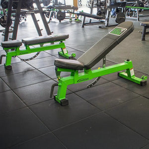 Green and black weight bench in a gym setting