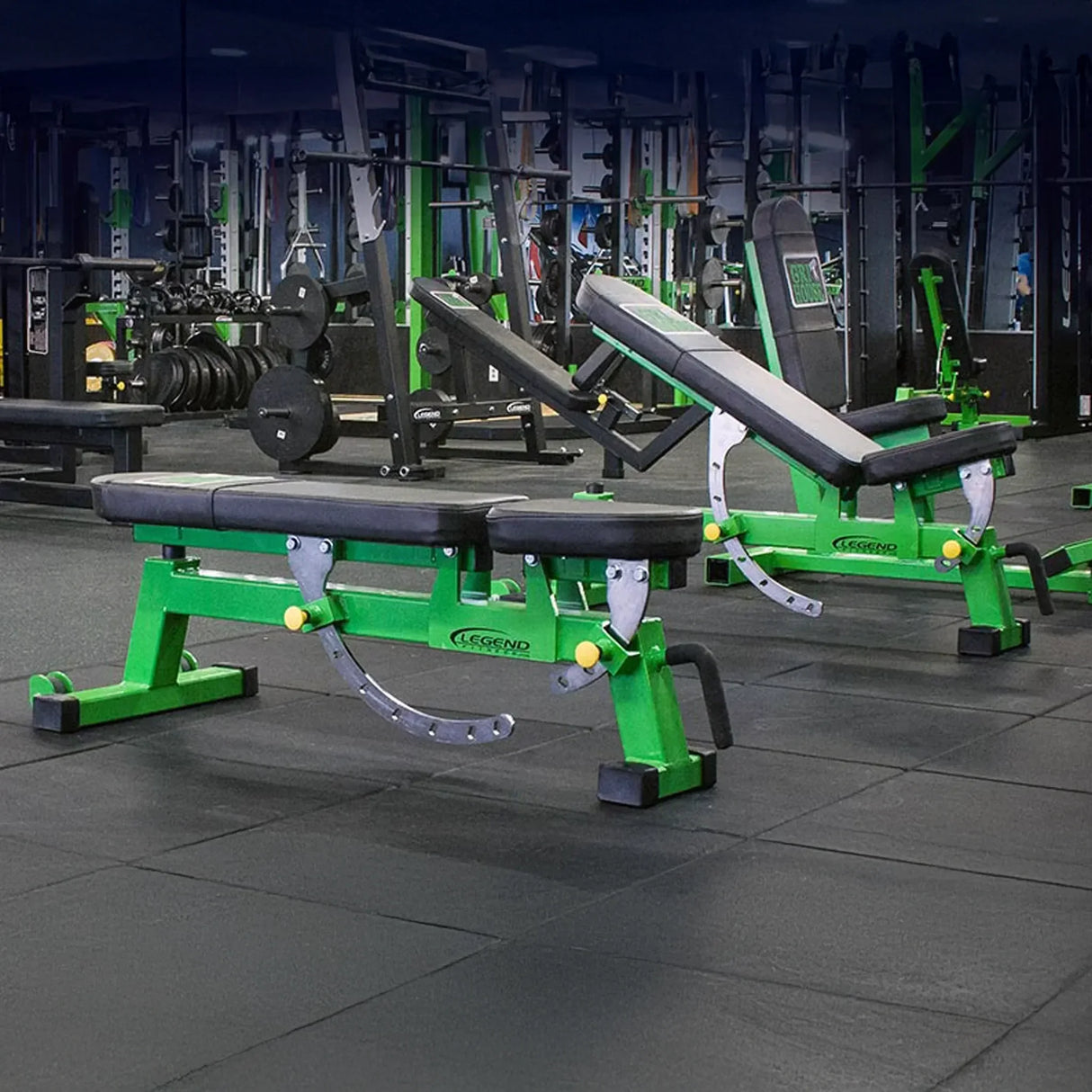 Green weight bench in a gym setting with various equipment in the background