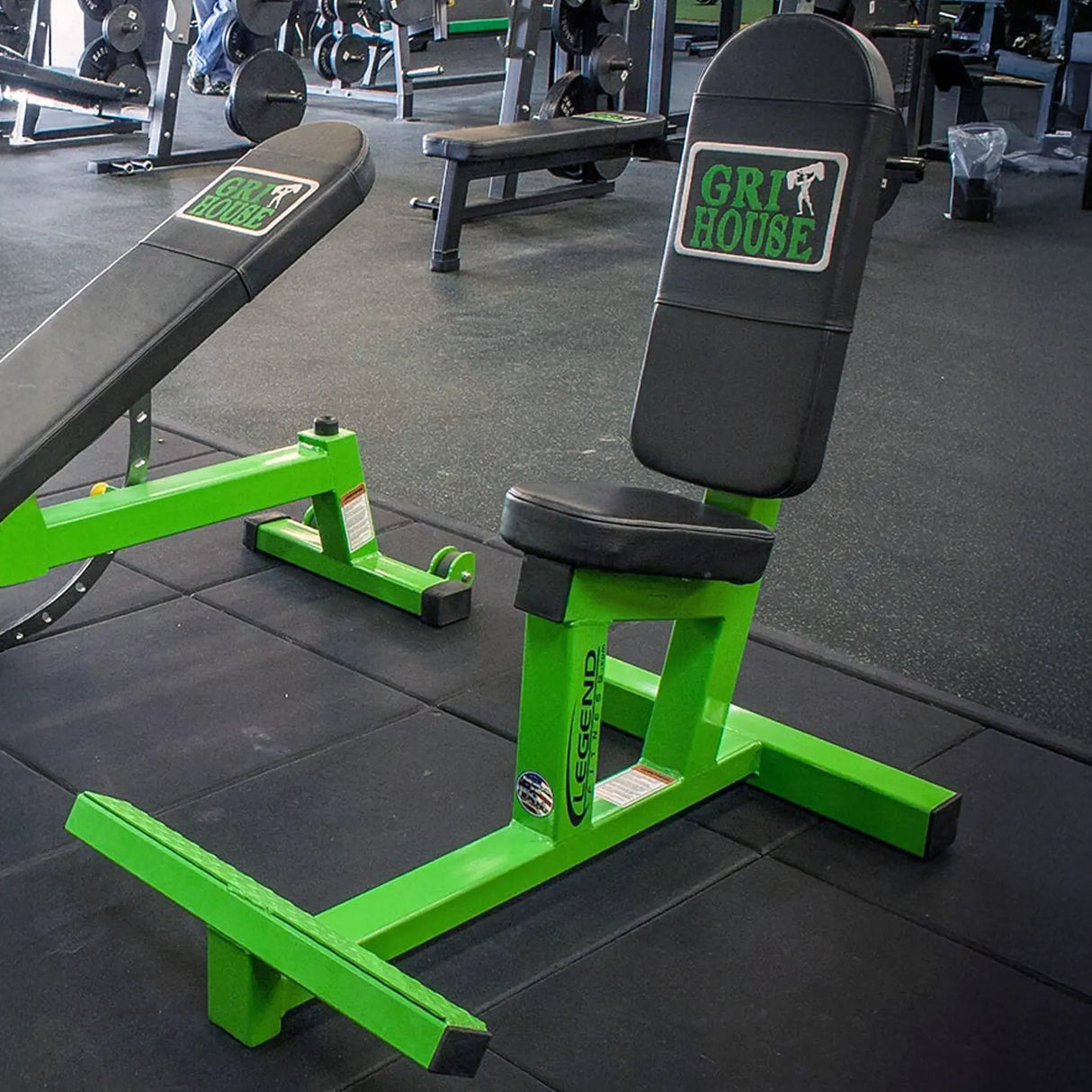 Green and black multi-purpose weight bench with 'Gri House' branding in a gym setting