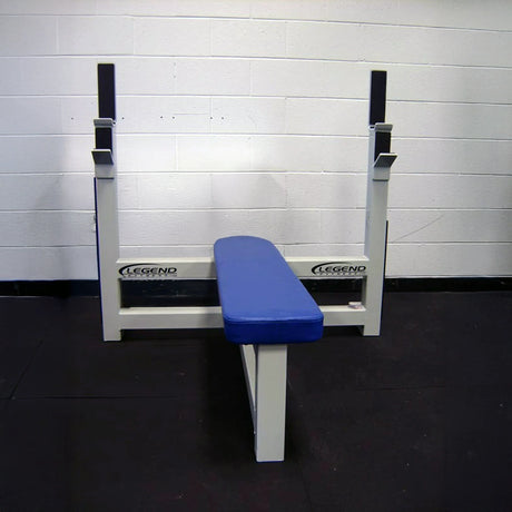 Blue weight bench with white frame against a white wall.