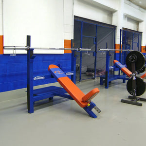 Gym equipment including a blue and orange weight bench in a warehouse setting.