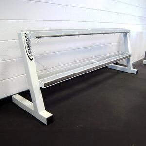 A white empty dumbbell rack against a white wall on a black rubber floor