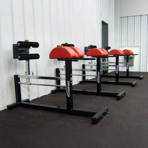 Four black and red glute ham developer fitness machines in a gym setting