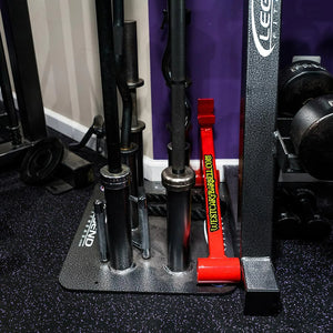 Close up image of a black and silver barbell holder full of barbells on a gym floor