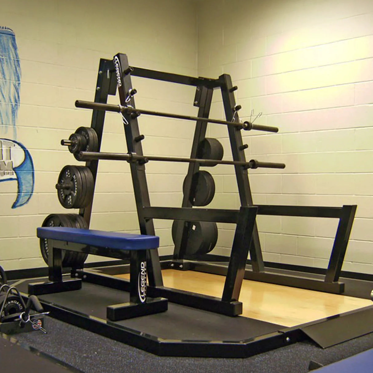 A black peg squat rack with two barbells and plates in a gym