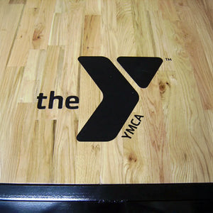 Black YMCA logo on a wooden surface