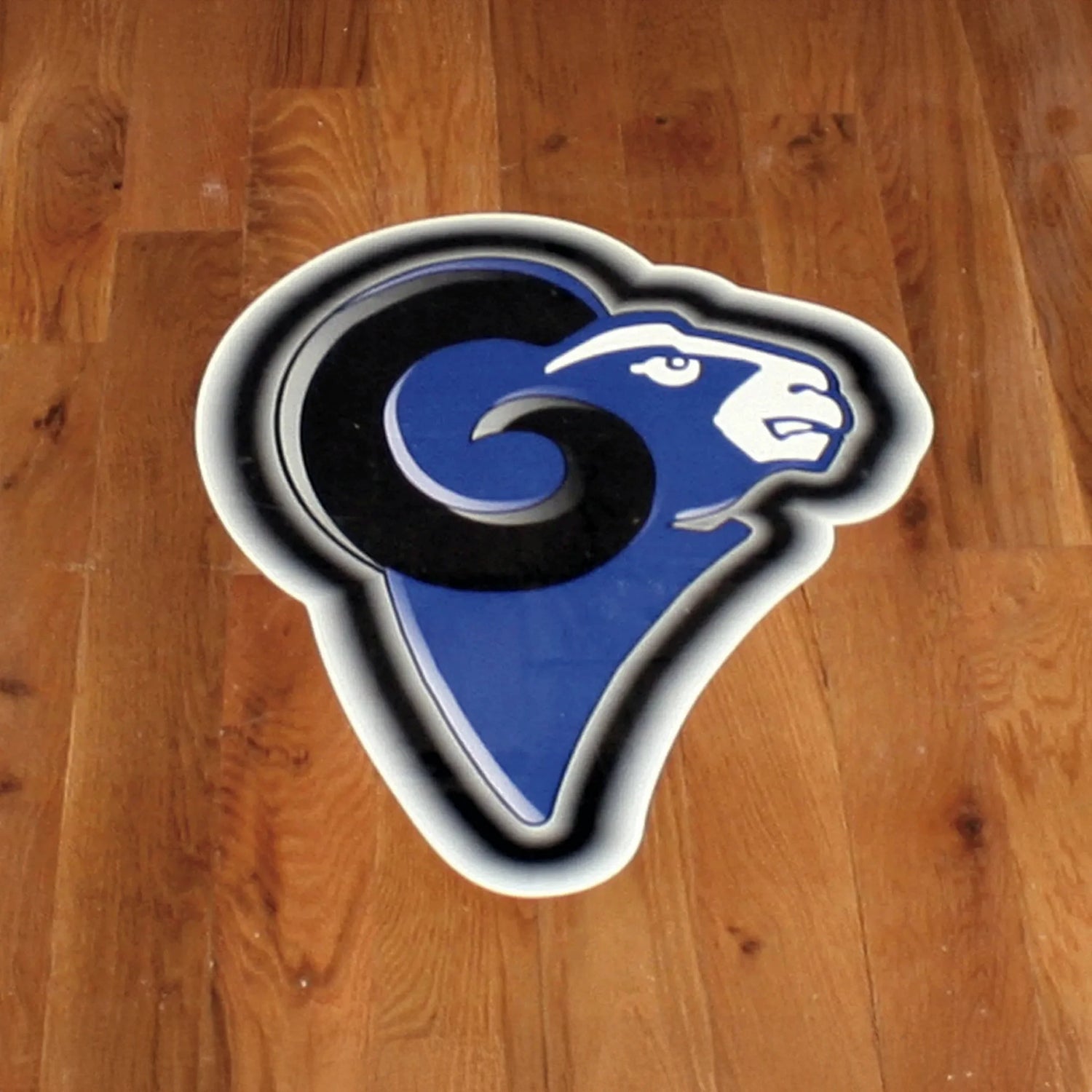 Blue and black ram logo on a wooden surface
