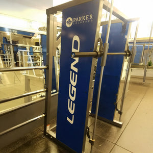A blue and silver Smith Machine made by Legend Fitness with a Parker Colorado logo on the shroud
