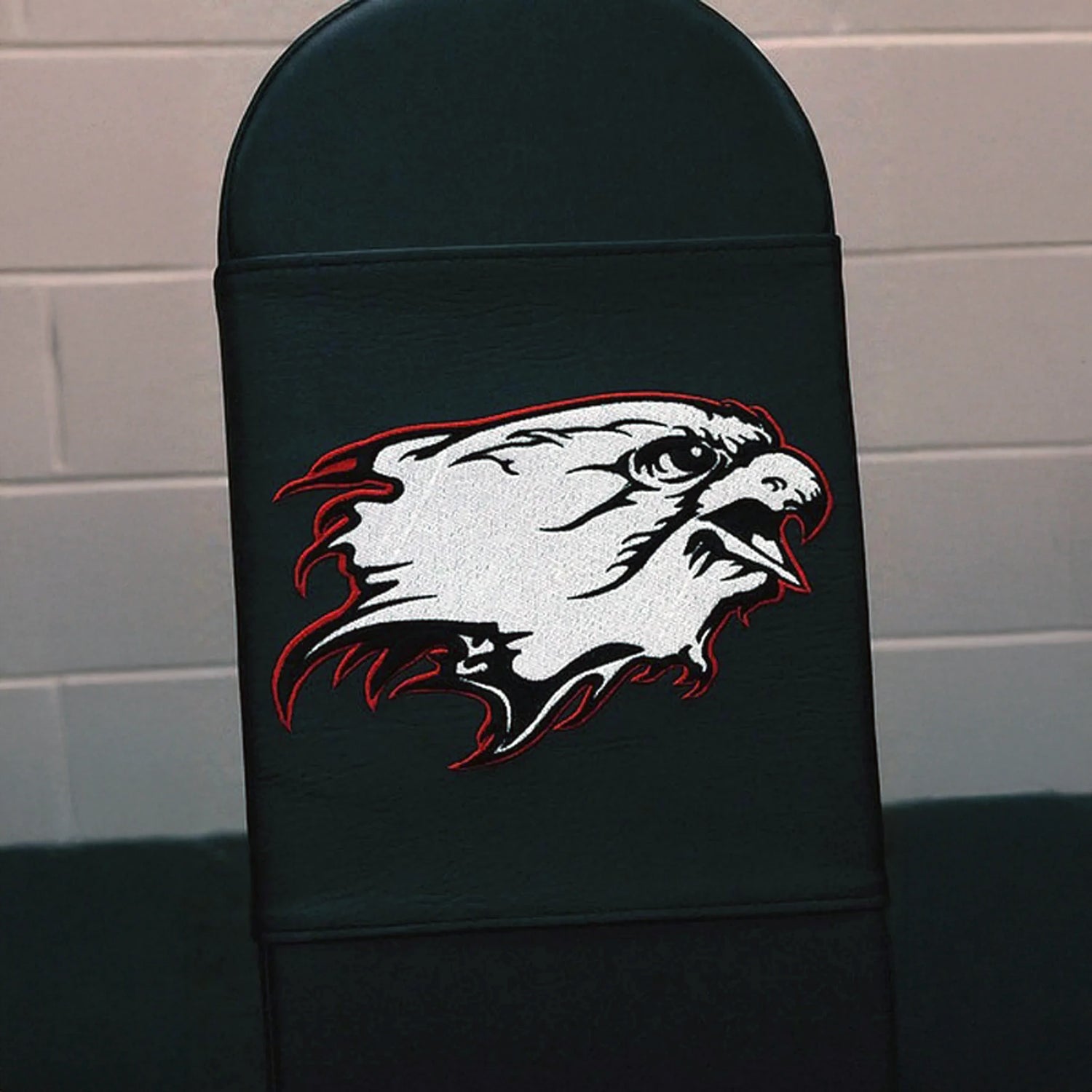 A black gym bench pad with a white and red eagle logo embroidered on it