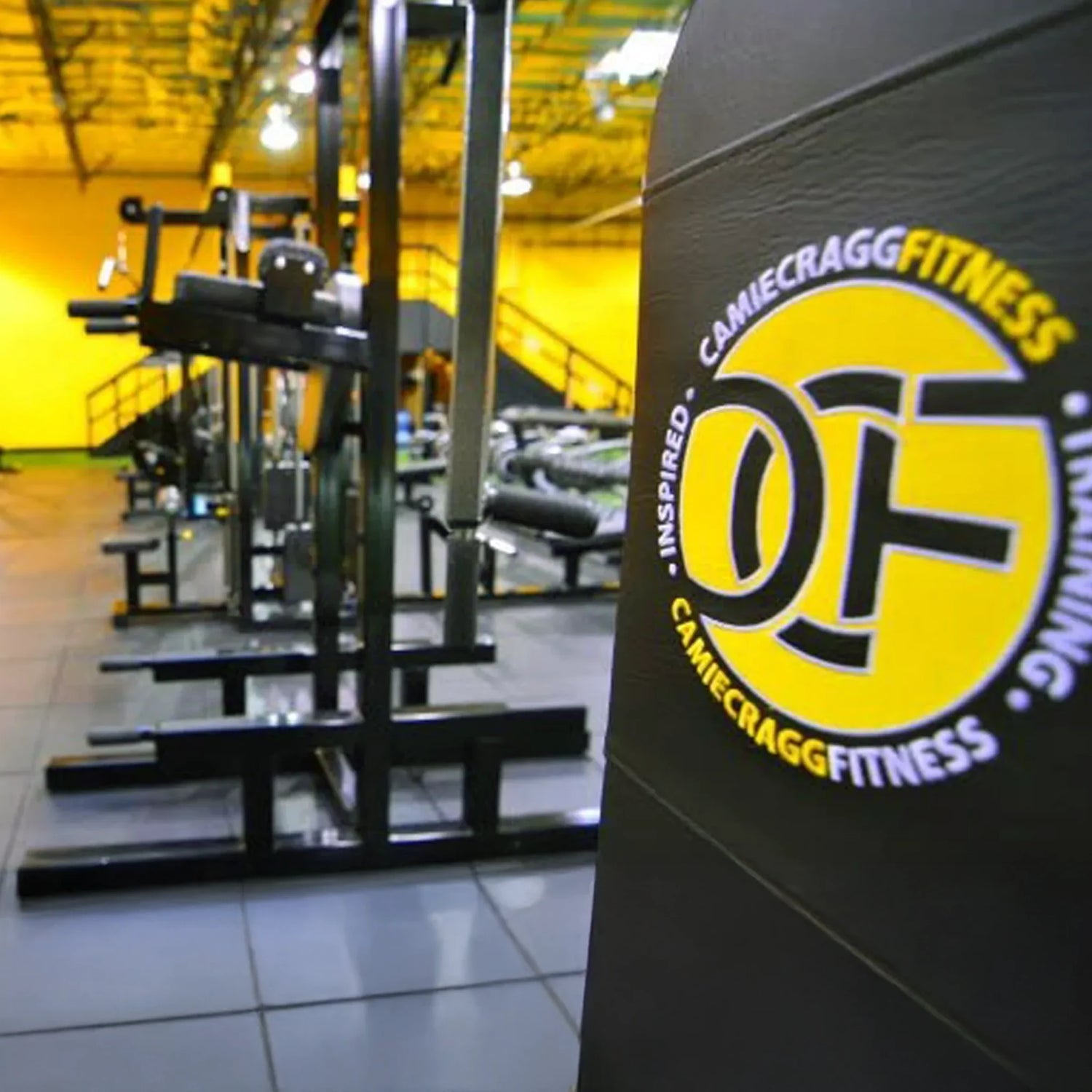 Gym equipment with Camie Cragg Fitness branding in a fitness center.
