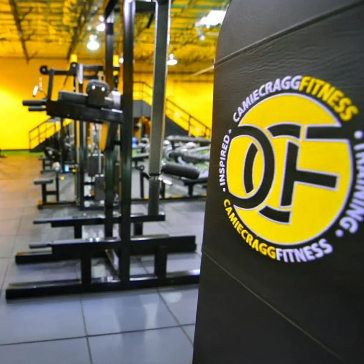 Gym equipment with Camie Cragg Fitness branding in a fitness center.