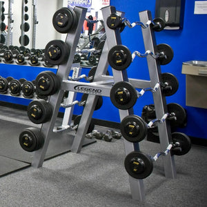 A silver barbell storage rack with ten barbells stored on it in a gym setting with a blue wall in the background