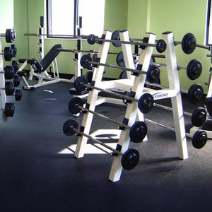 A gym full of equipment including a white barbell storage rack in the foreground