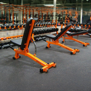 Orange weight bench in a gym setting with multiple benches and equipment.