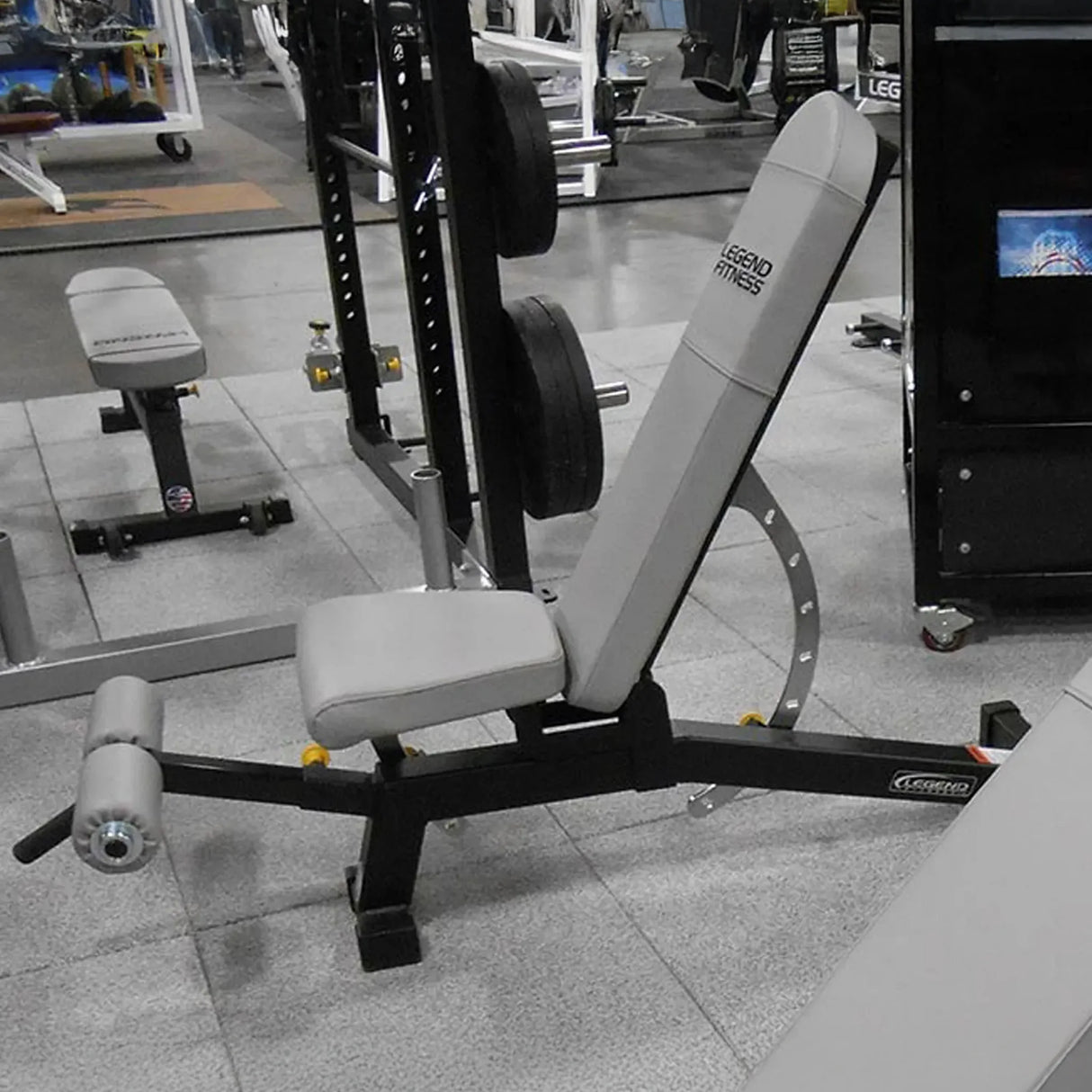 Gray and black weight bench on a gray floor in a gym setting