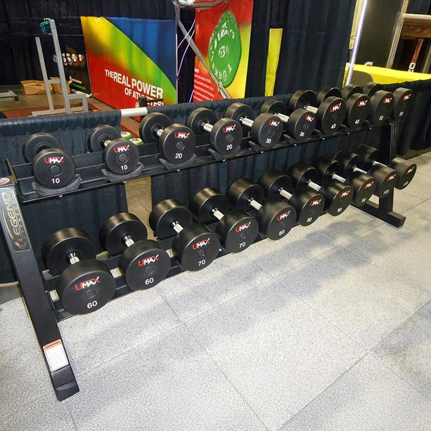 Set of dumbbells on a rack with colorful banners in the background