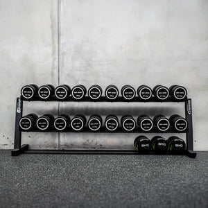 Set of dumbbells on a rack against a concrete wall.