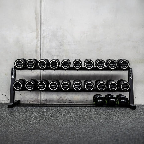 Set of dumbbells on a rack against a concrete wall.