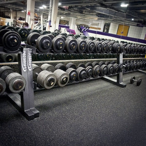 Multiple dumbbell racks in a row with dumbbells on them in agym setting