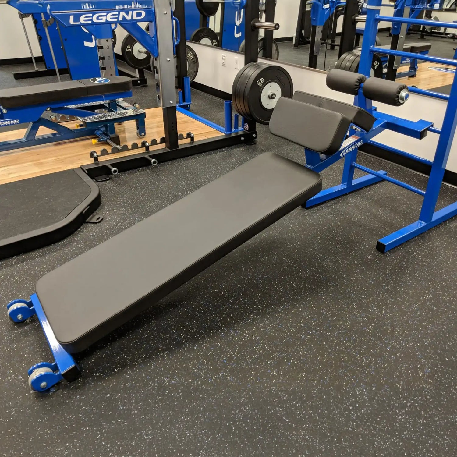 A blue and black sit up bench in a gym setting