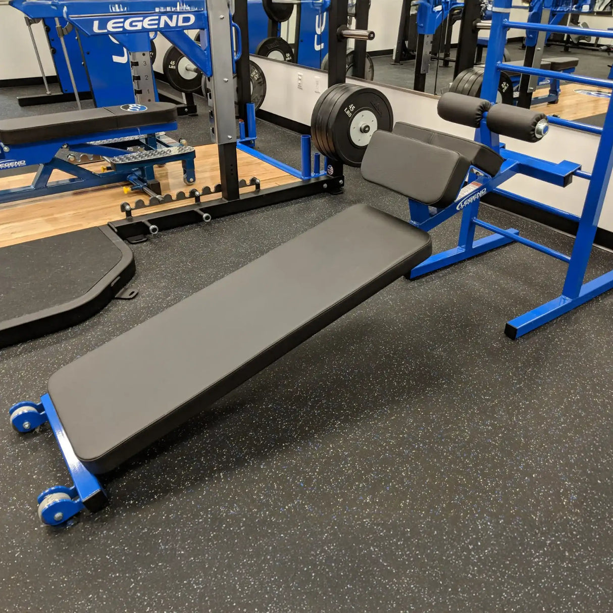 A blue and black sit up bench in a gym setting
