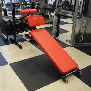 A silver and black sit up bench in a gym setting
