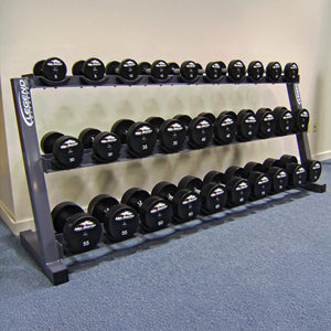 Dumbbell rack with weights on a blue carpeted floor against a beige wall.
