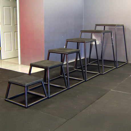 A row of six black metal gym step up boxes in a gym setting