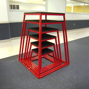 A set of six red metal fitness boxes Stacked neatly one on top of each other in a gym setting