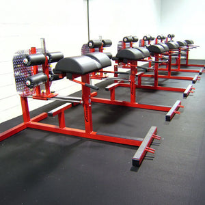 A row of red and black glute ham developer fitness machines in a gym setting