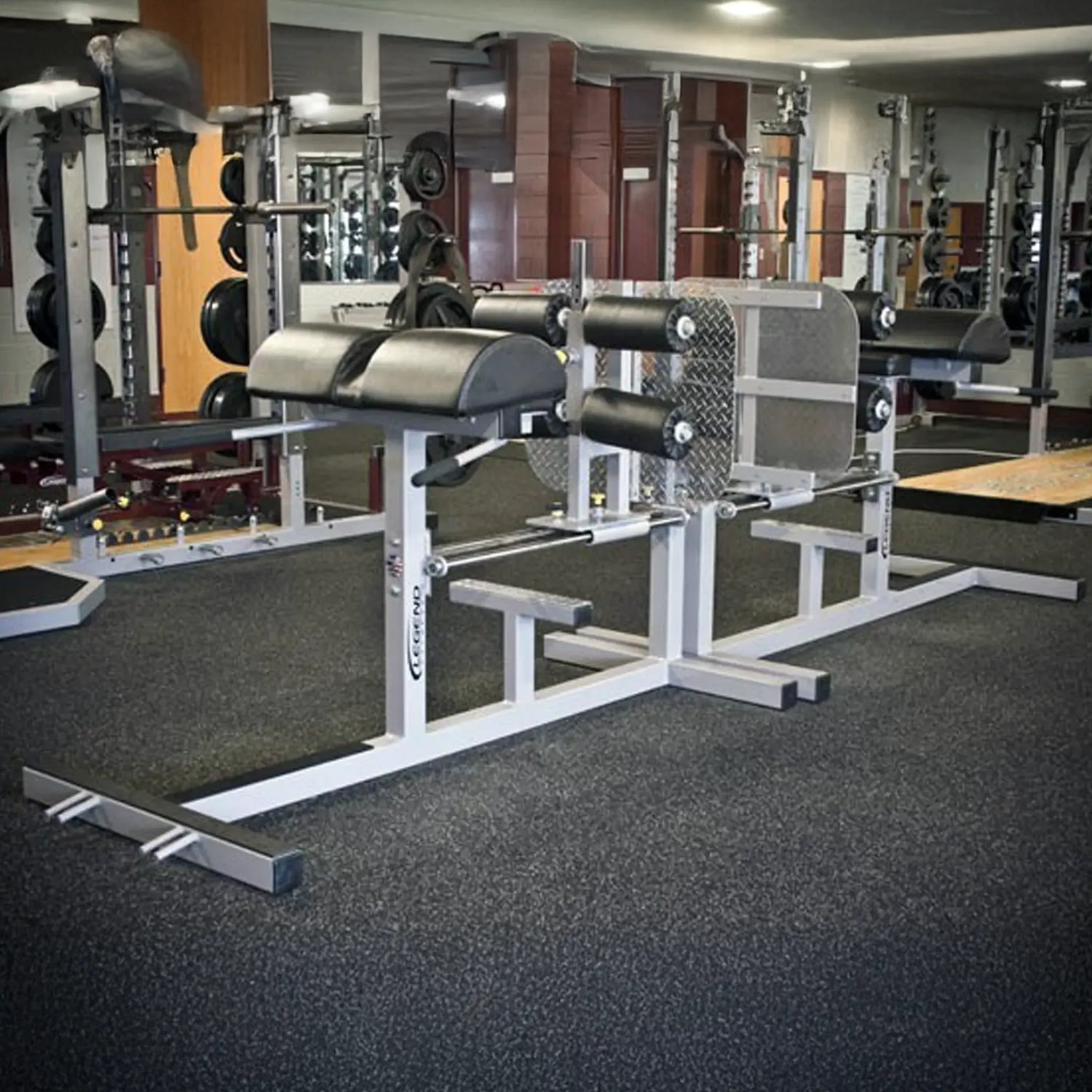 Gym equipment including weight racks and benches in a fitness center.