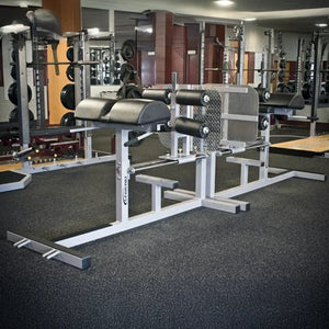 Gym equipment including weight racks and benches in a fitness center.