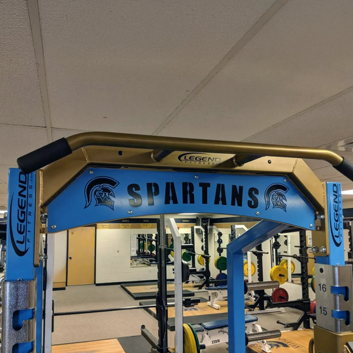 Gym equipment with 'Spartans' branding in a fitness center.