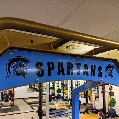 Gym equipment with 'SPARTANS' branding in a fitness center.