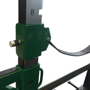A green mount for a nylon safety strap mounted on a squat rack