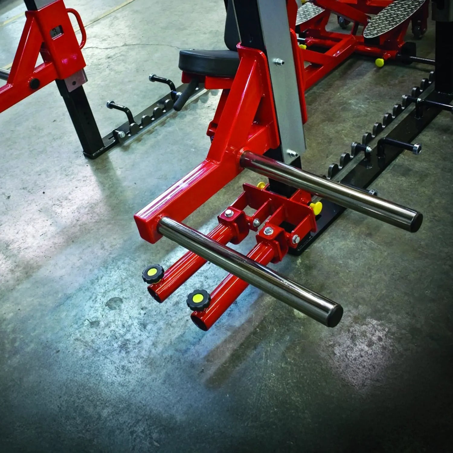 Red weightlifting bench with metal bar on a concrete floor