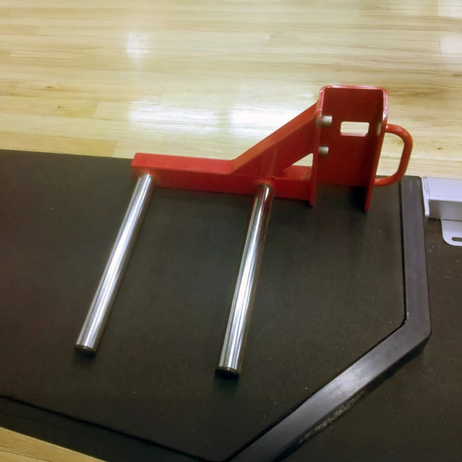 A red metal technical tray squat rack attachment sitting on a weight lifting platform