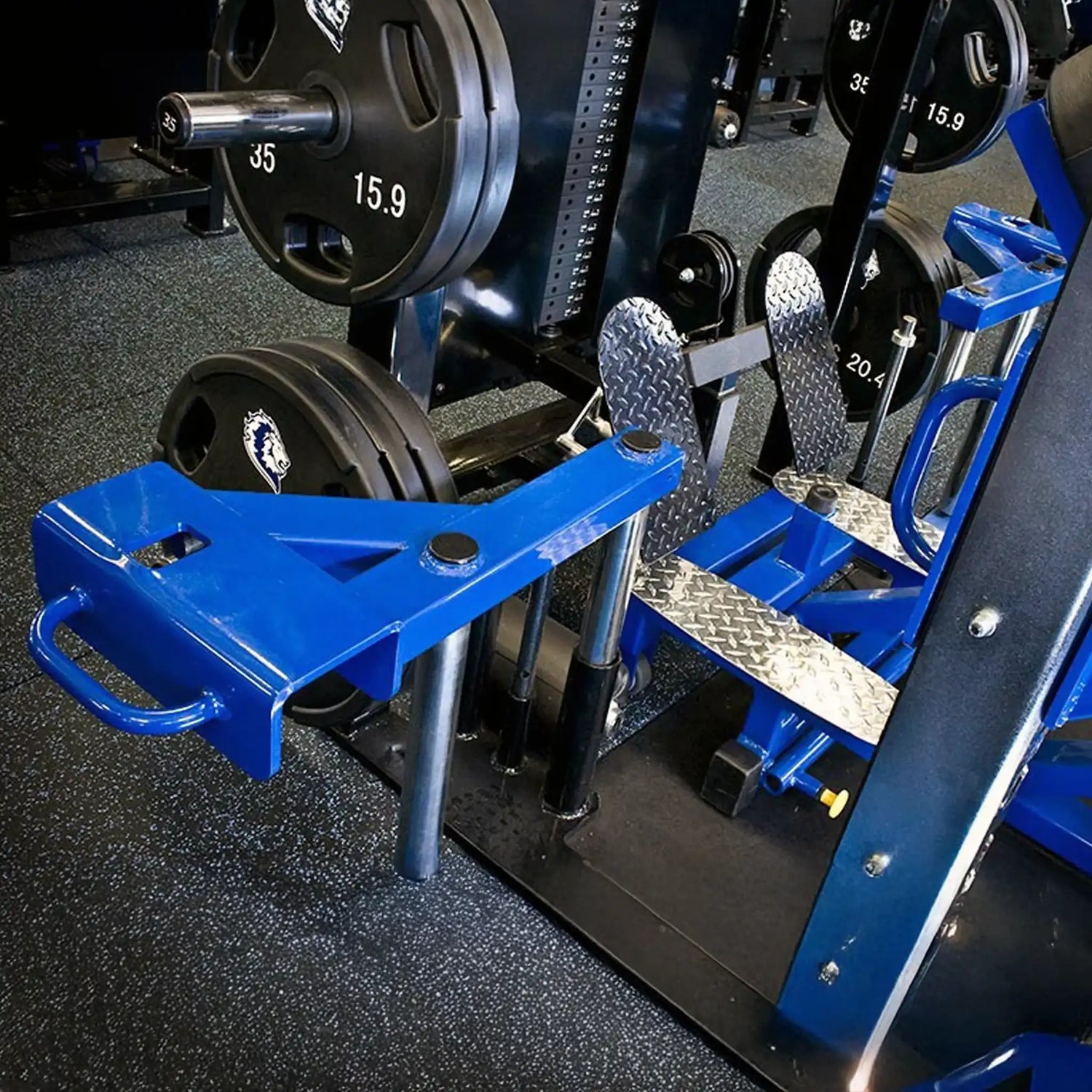 Blue, black, and silver weightlifting equipment with black plates on a black and white speckled gym floor