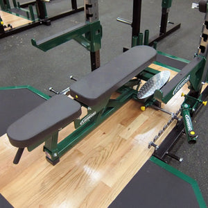 Green weight bench with a black pad in a gym setting