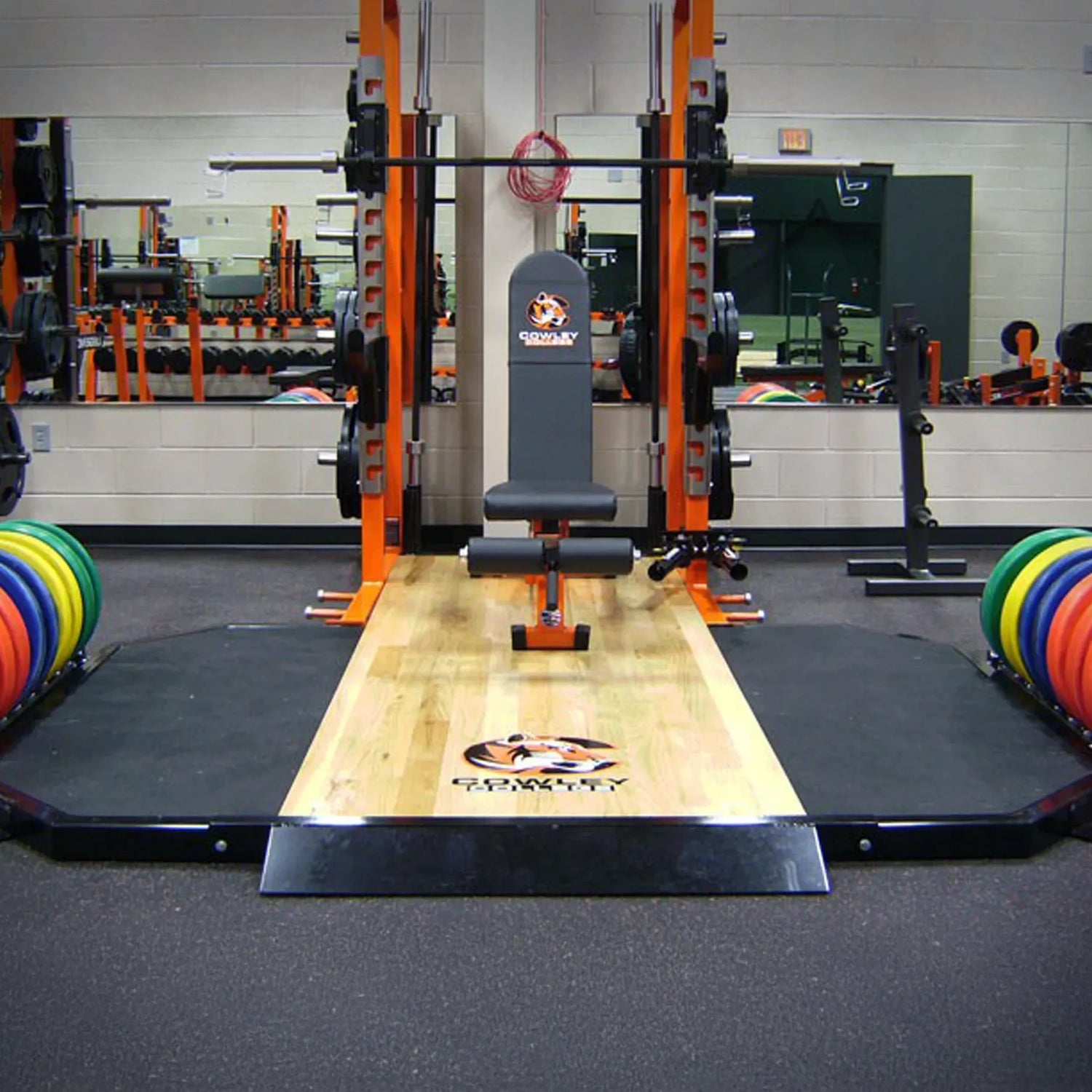 Gym equipment with a weightlifting platform and weights in a fitness center.