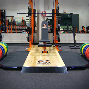 Gym equipment with a weightlifting platform and weights in a fitness center.