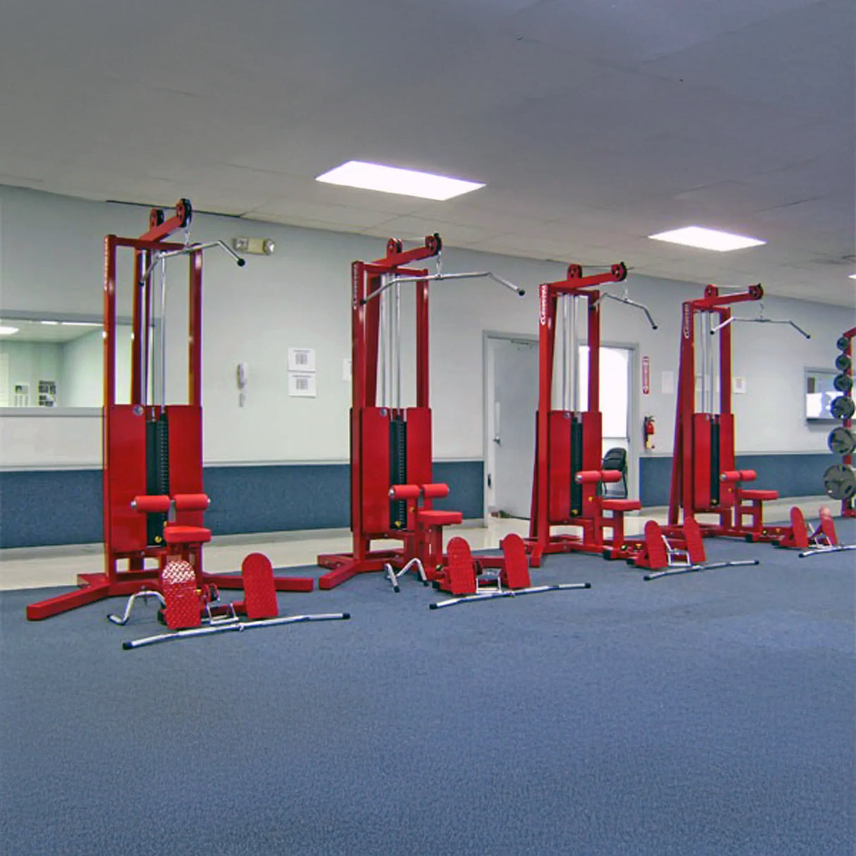 A row of lat pulldown floor row gym machine on a blue floor in a gym