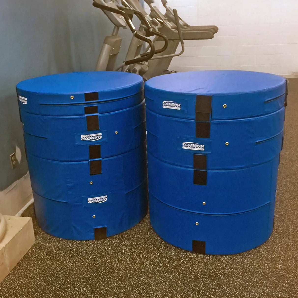 Two side by side blue round plyometric cushions in a gym setting