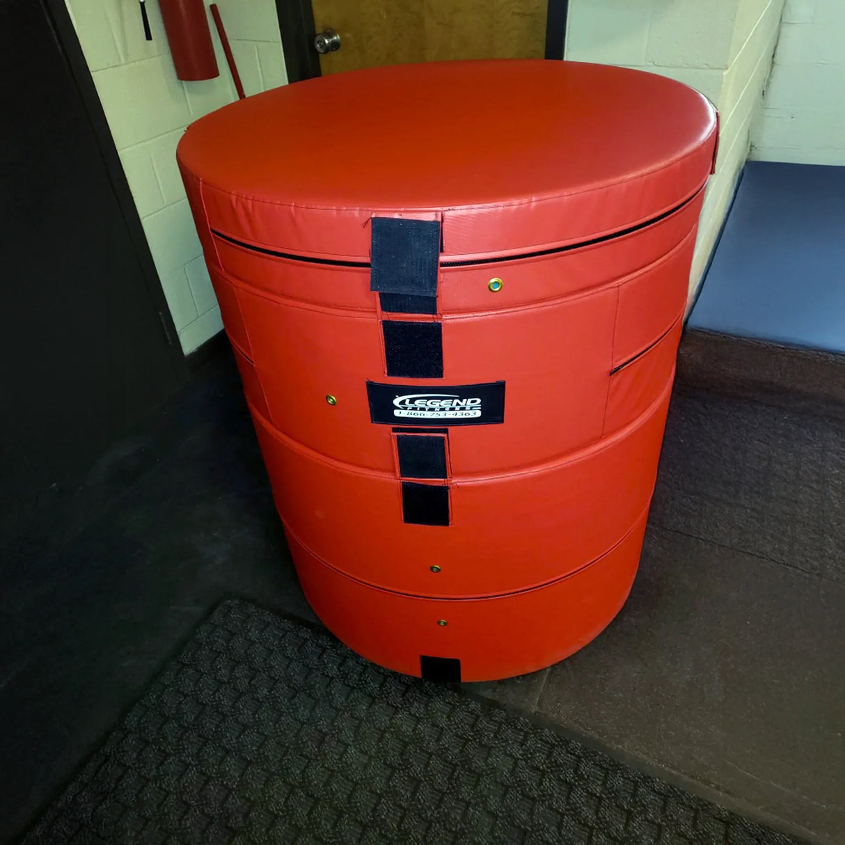 A round red plyometric cushion in a gym setting