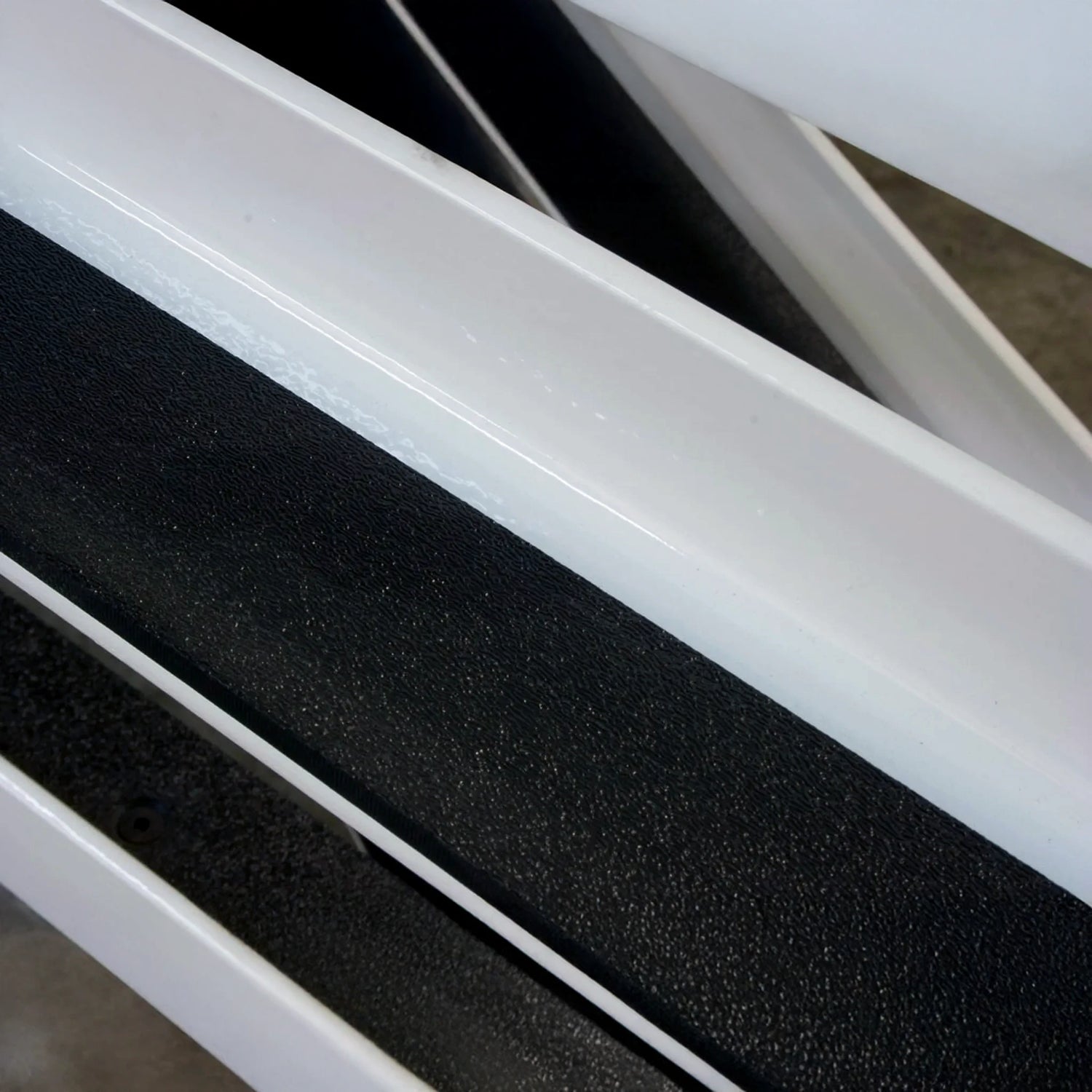 Close-up of white metal with black grip tape stuck to it