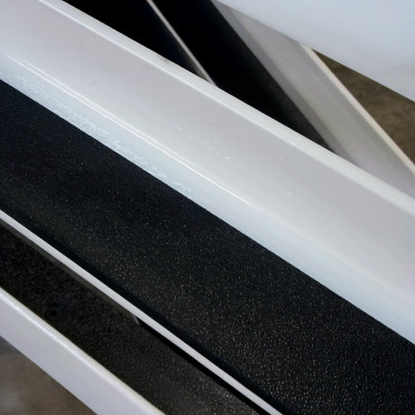 Close-up of white metal with black grip tape stuck to it